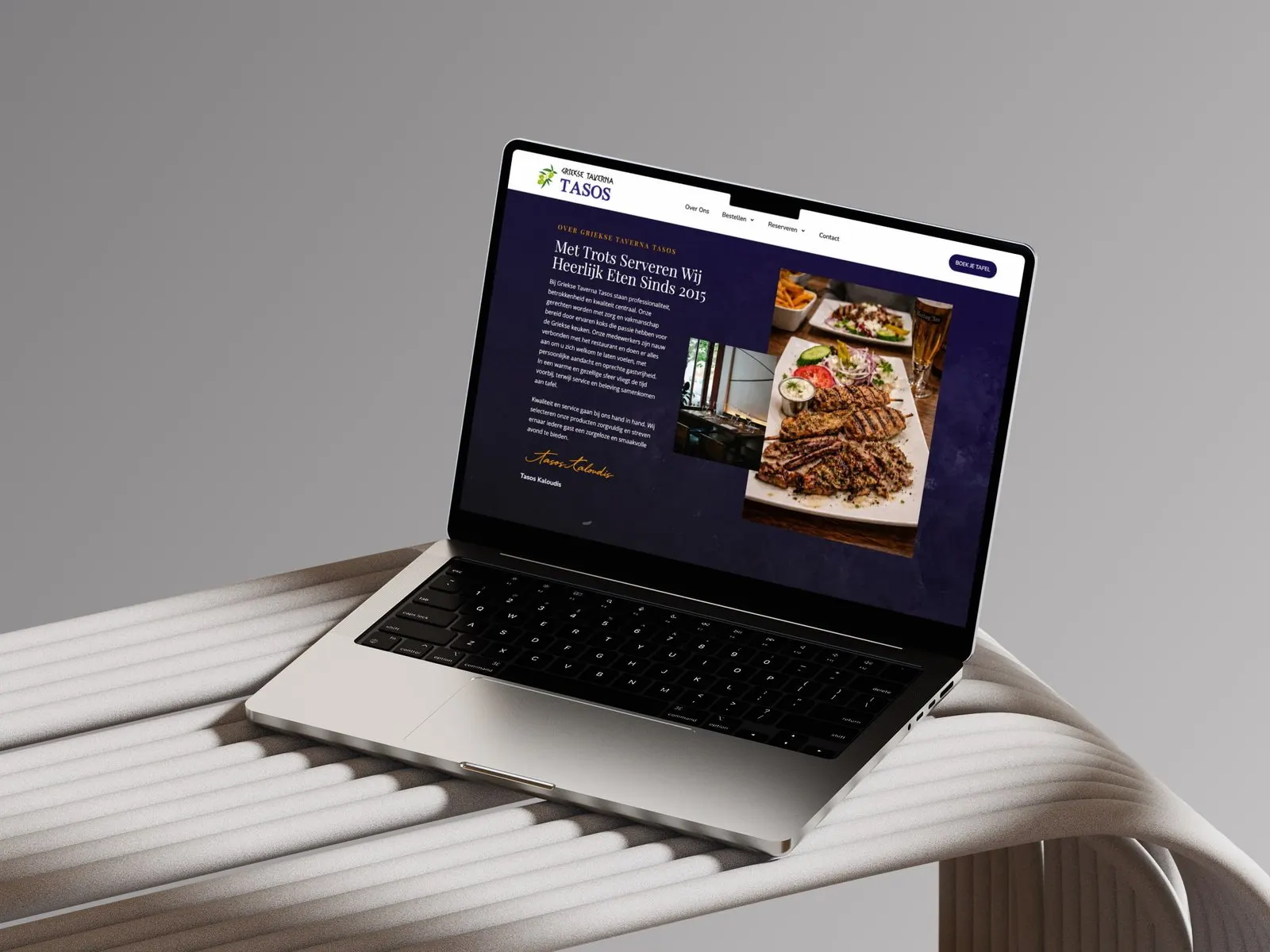Laptop met de website van Griekse Taverna Tasos op een stoel